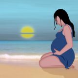 ビーチに座り込む妊婦さん