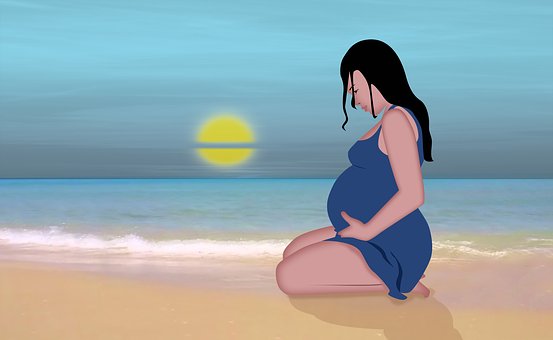 ビーチに座り込む妊婦さん