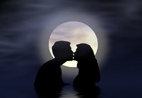 湖でキスをするカップルのシルエット